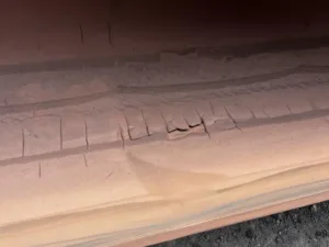 Repeated transverse cracks across the belt surface can be associated with flexing, ageing or local deformation and should be assessed together with conveyor geometry and operating history.